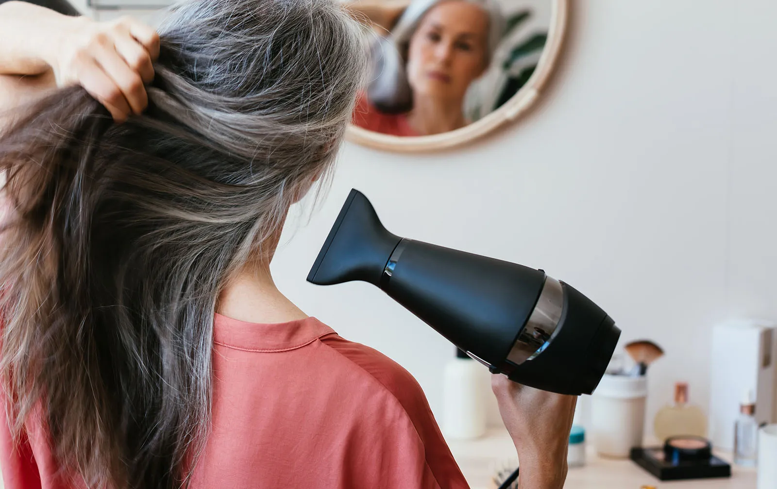Frau, die ihre langen Haare fönt